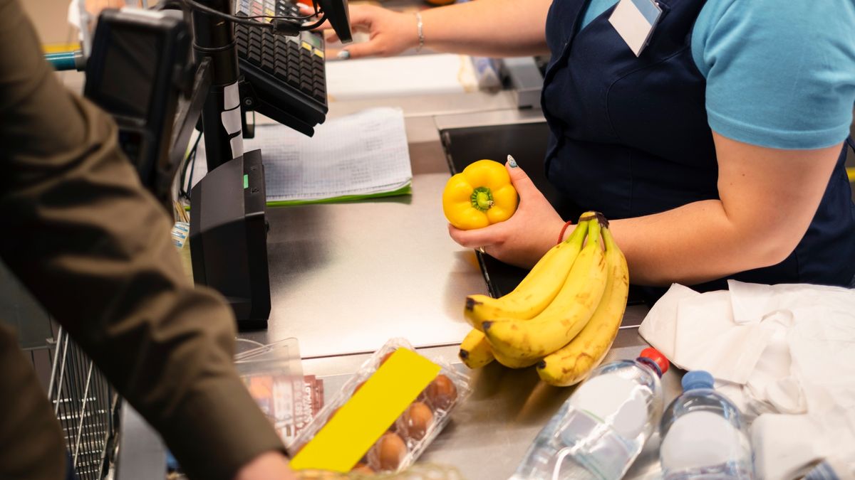 Una trabajadora de comercio atiende en la caja de un supermercado