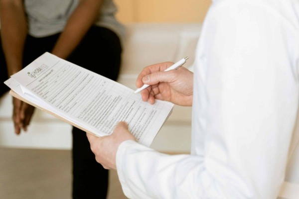 Persona con formulario medico en una sala de espera de salud